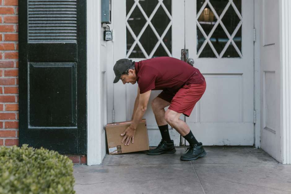 Delivery man leaving a package in front of the door