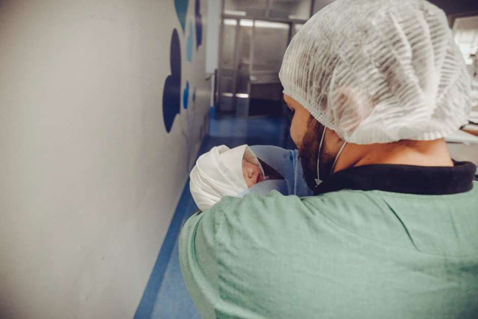 An image showing a healthcare worker cradling a newborn