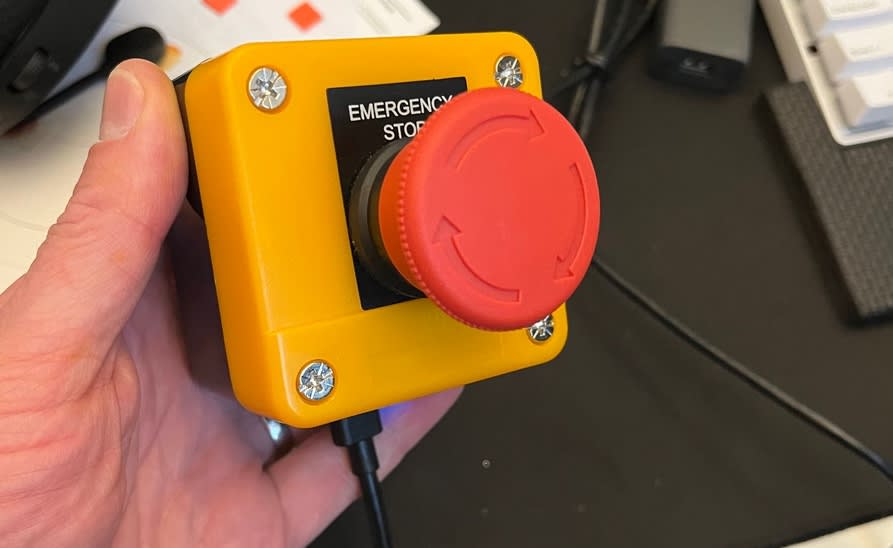 Person holding a standard emergency button