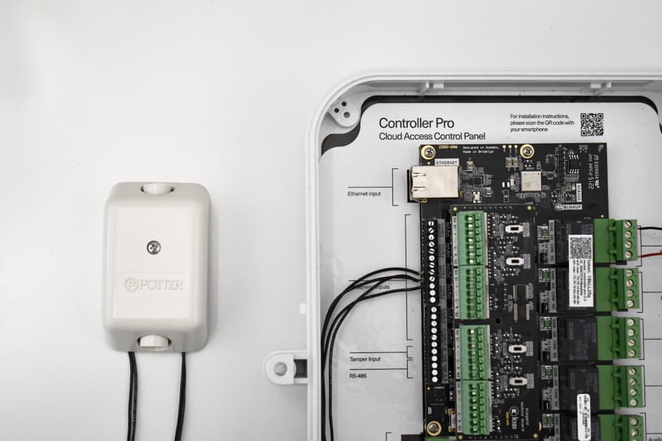 An image showing a Kisi Controller Pro 2 wired with a Potter Hub-T Two Button Hold Up Switch