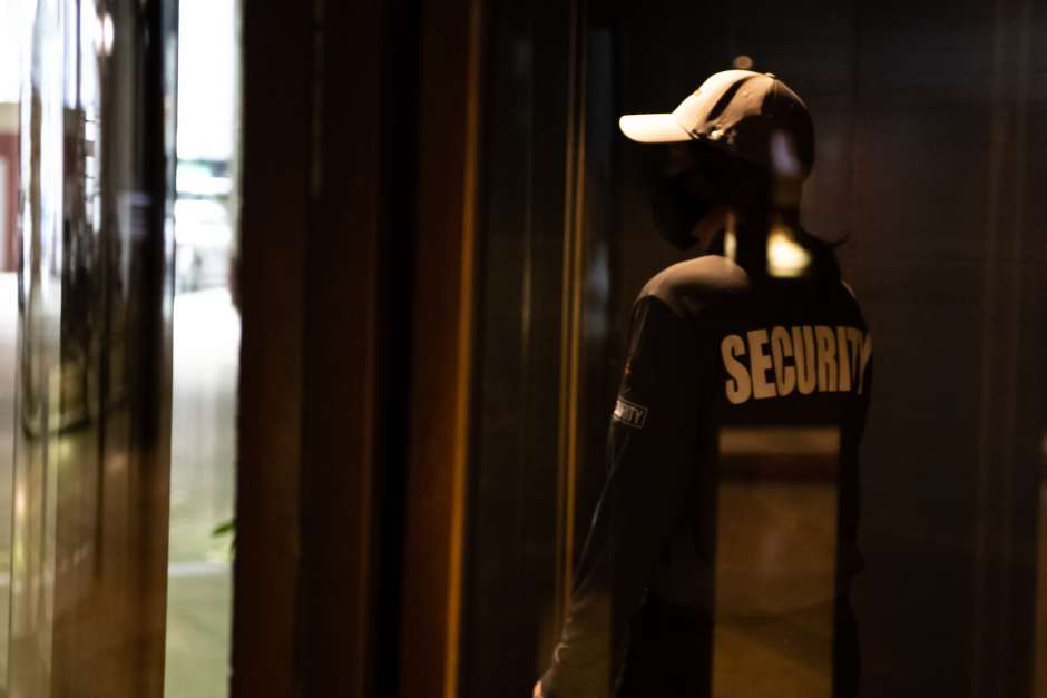 An image of a silhouette of a security guard in front of a facility entrance 