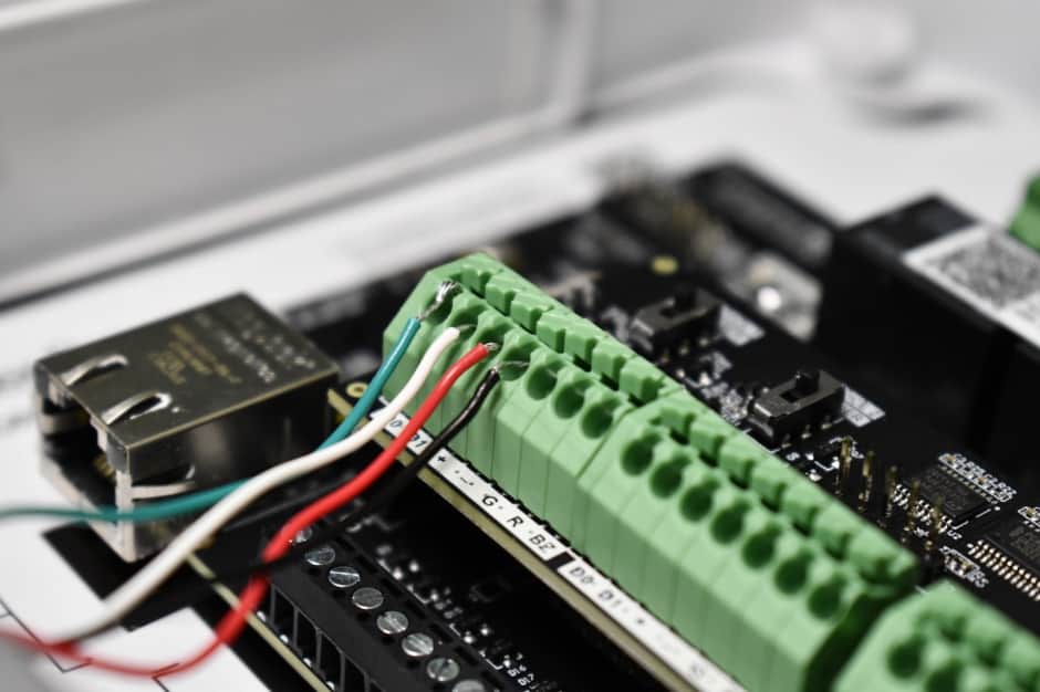 a close up of a Kisi access panel wired to a proximity reader