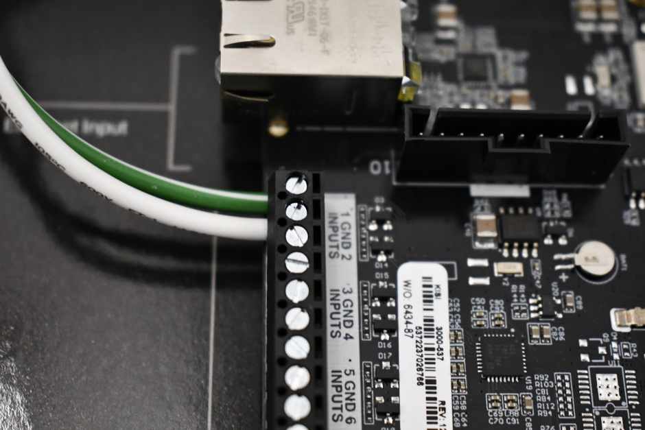 A close up of the wiring of a push to exit button with the Kisi access control panel