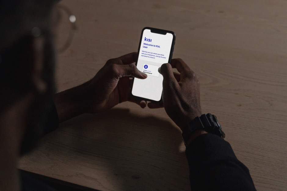 an image of a person holding a smartphone to onboard on the Kisi access control app