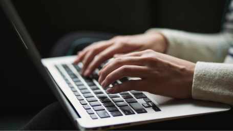 An image of a person working on a laptop