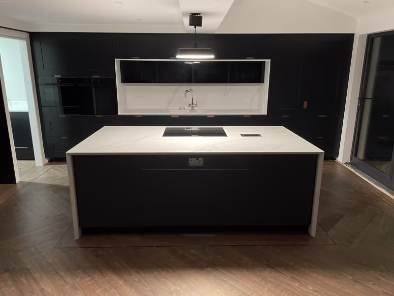 bank of kitchen cabinets with integrated sink and appliances with waterfall island