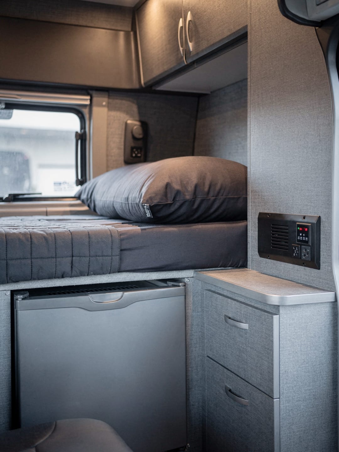 Inside a sleeper cab: the bunk, a small fridge and an inverter. The kind of sleeper setup our tractors have.