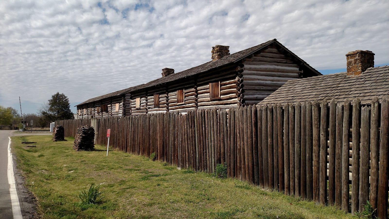 The log barracks and stockade fence of the reconstructed fort at Fort Gibson Historic Site.