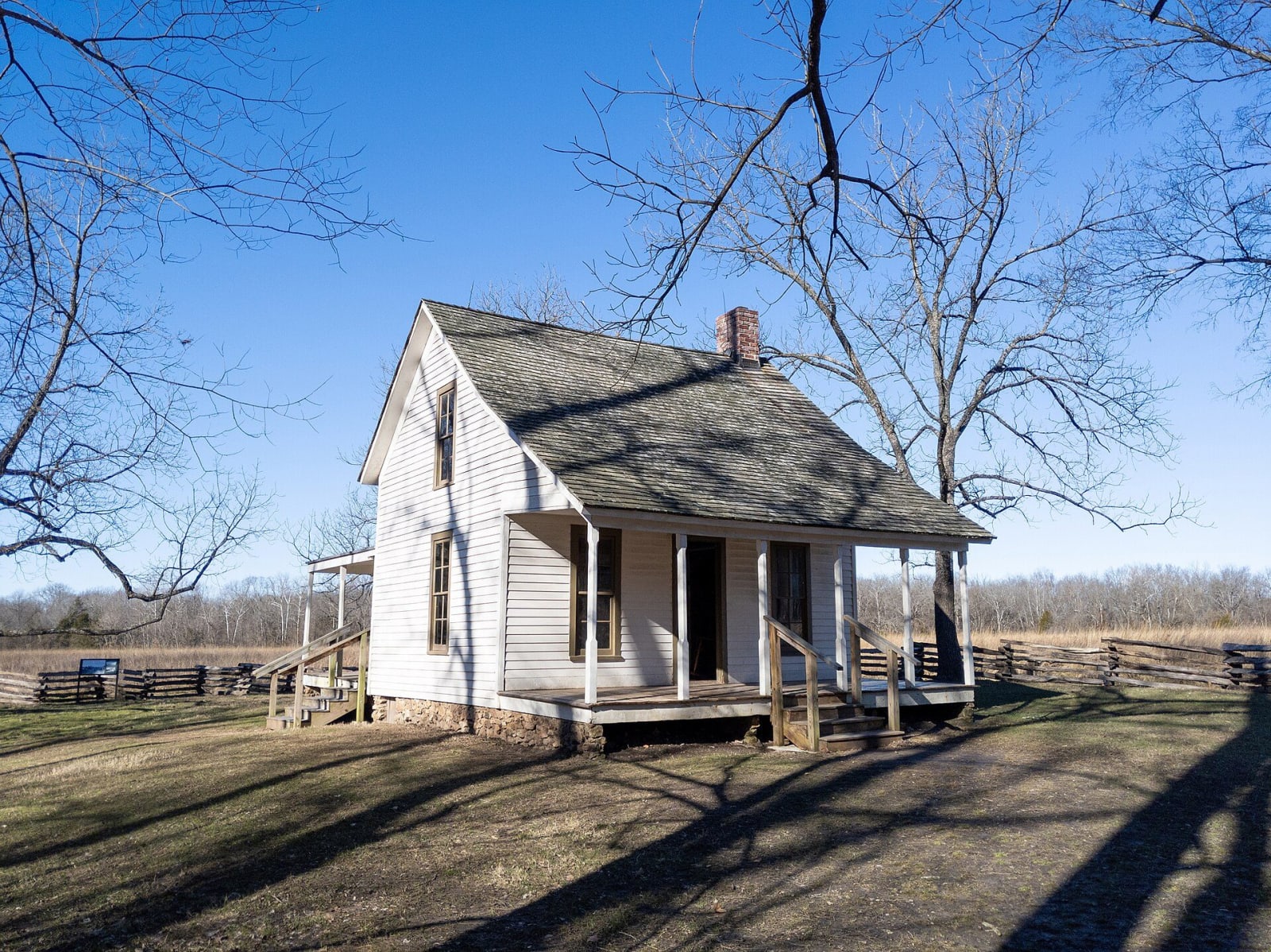 The white Moses Carver house under bare trees at George Washington Carver National Monument.