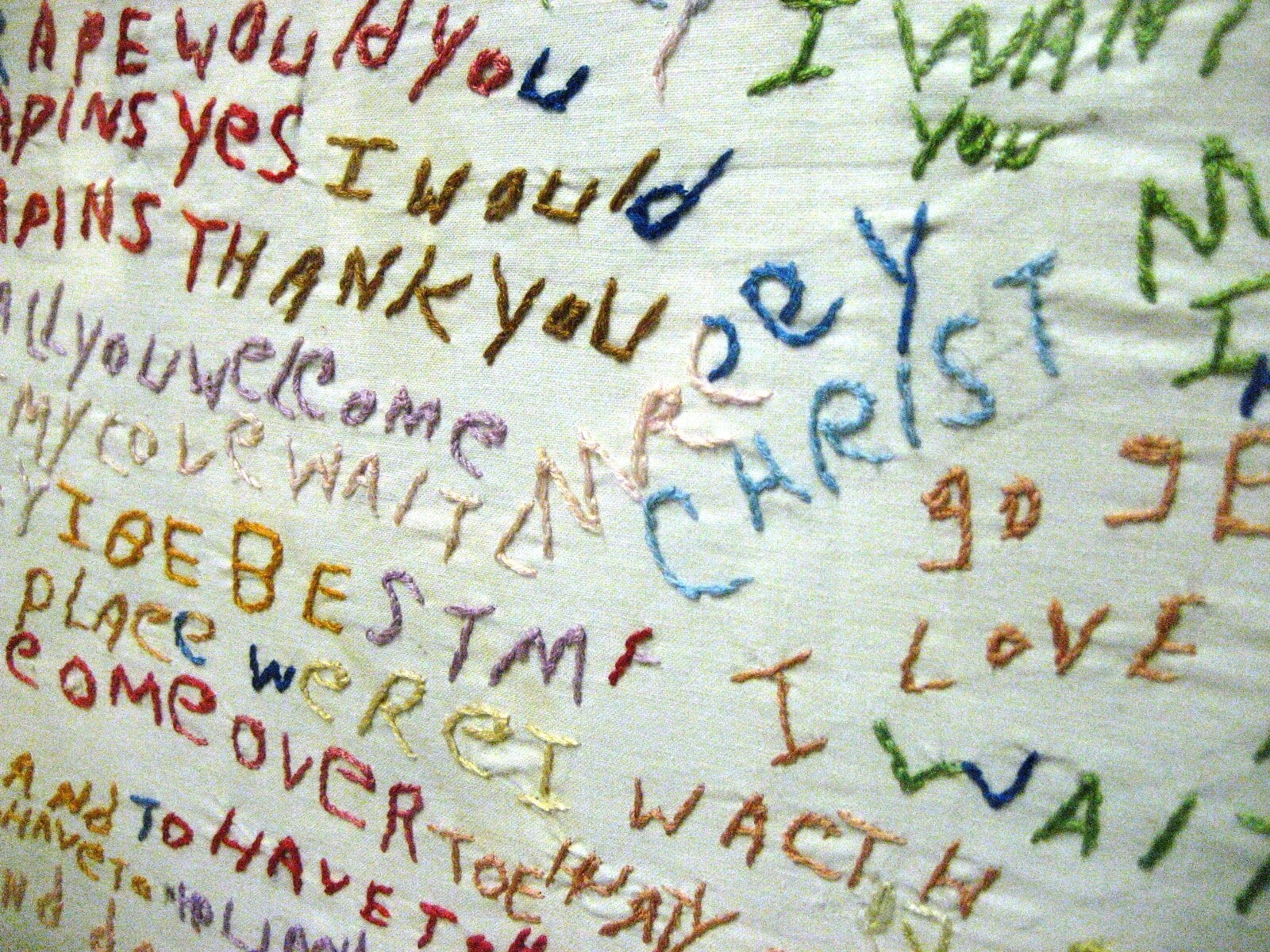A cloth embroidered by a patient with words and phrases in many colors of thread, displayed at the Glore Psychiatric Museum.