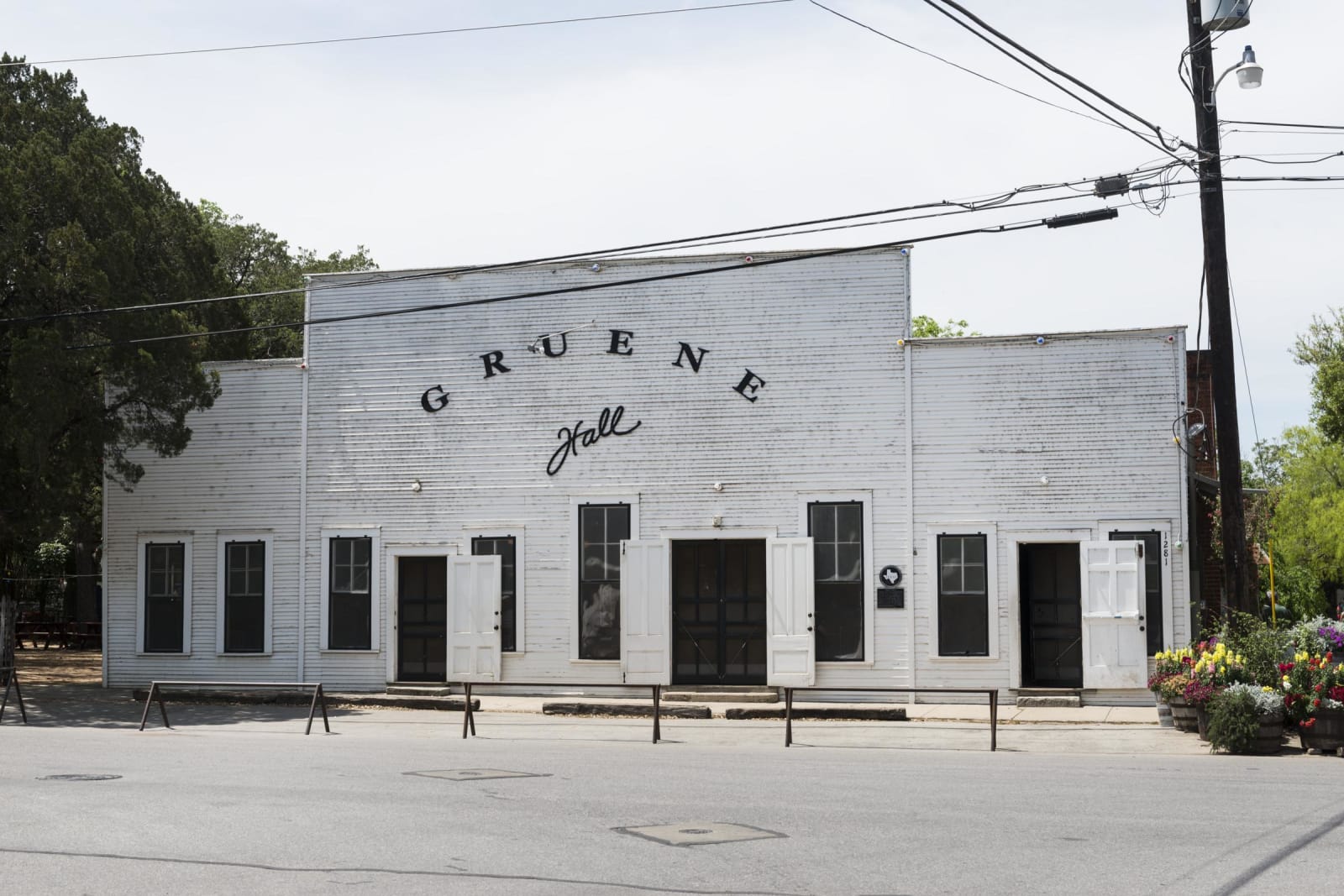 The white wooden front of Gruene Hall in New Braunfels, its name painted above a row of doors and shuttered windows.