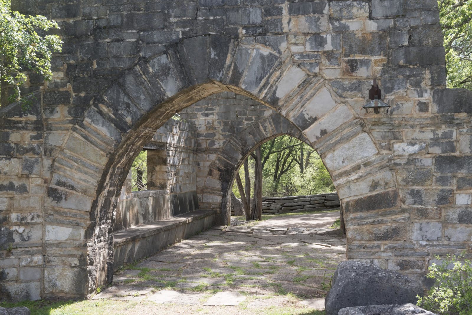 Arched stone walls and a stone walkway built by the Civilian Conservation Corps near the entrance to Longhorn Cavern.