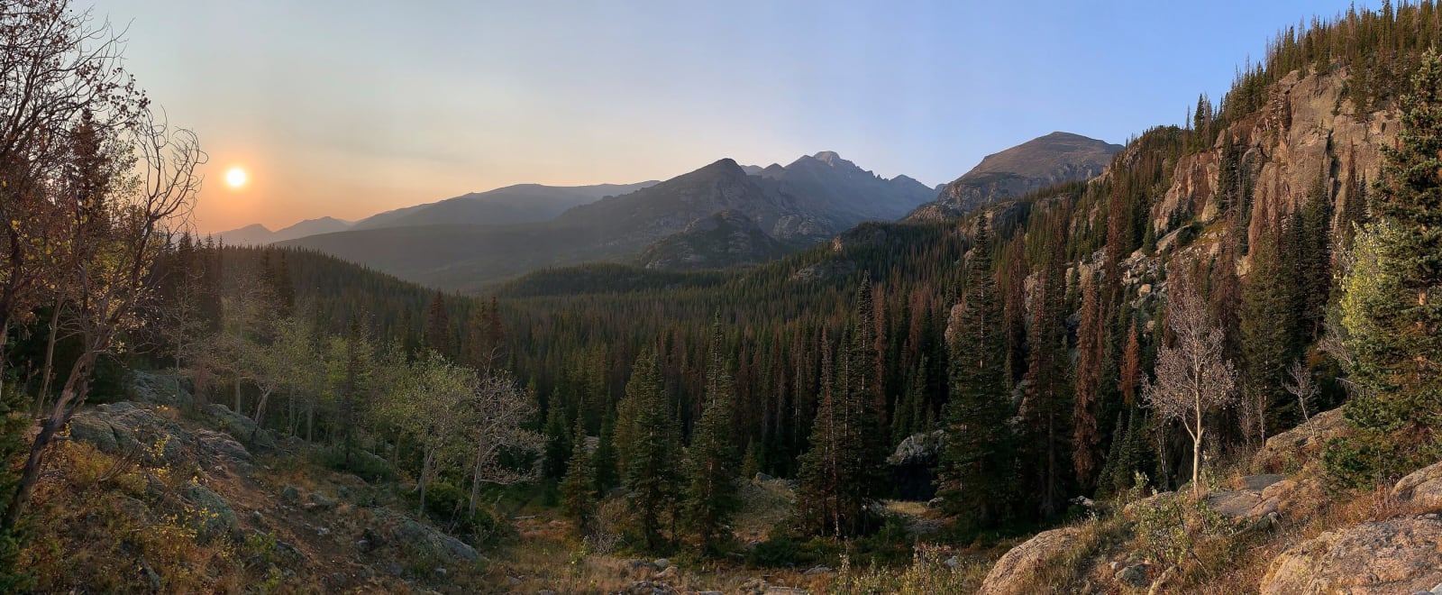 Sunrise over Longs Peak and the forested valleys below, seen from the Dream Lake trail in Rocky Mountain National Park