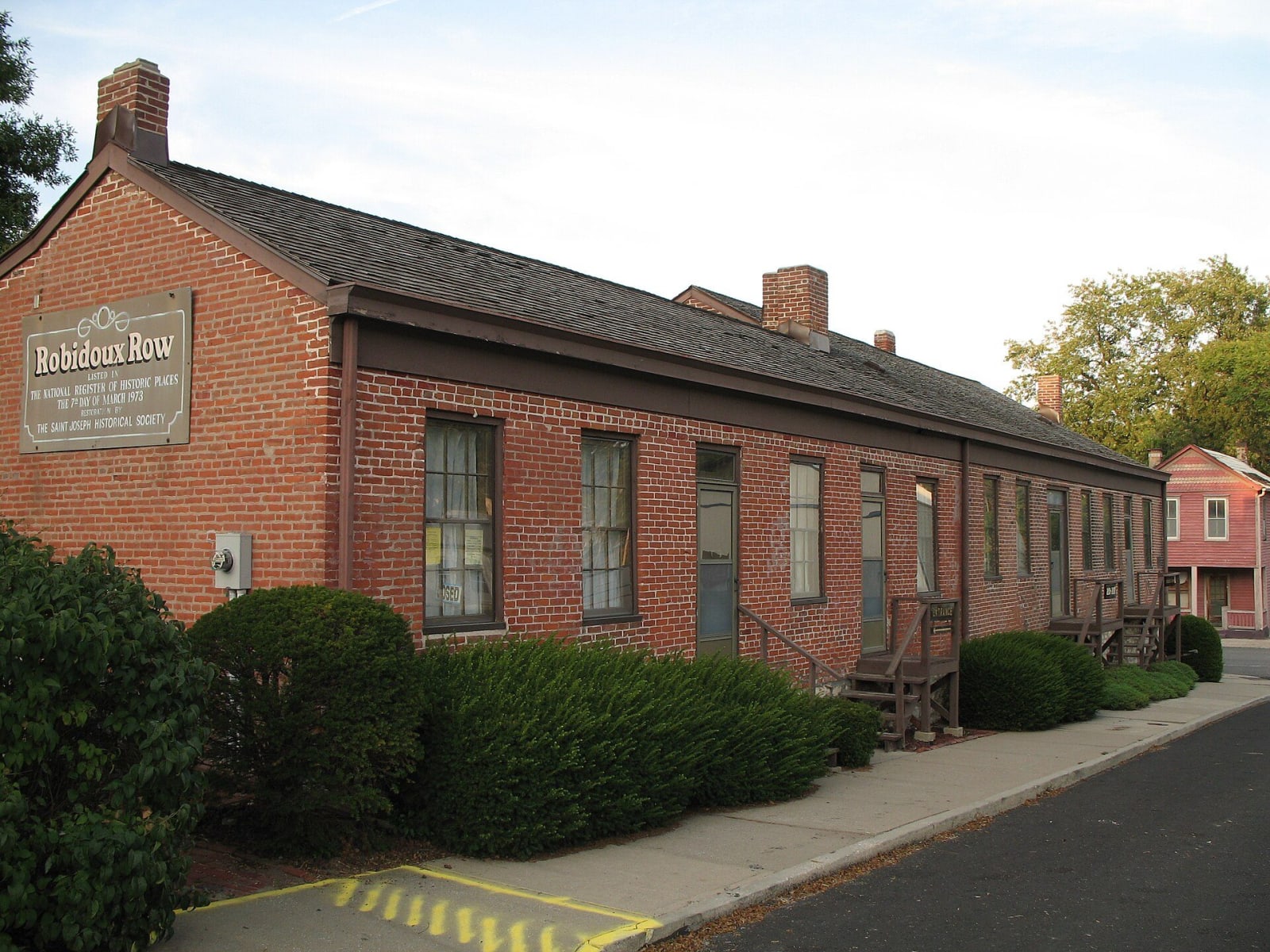The long one-story brick Robidoux Row in St. Joseph, with its sign at the near end.