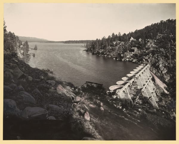 The 1912 Bear Valley Dam soon after completion, its row of concrete arches carrying a walkway, with Big Bear Lake behind.