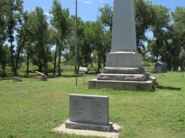The Beecher Island battle monument and a granite name tablet among cottonwoods by the Arikaree