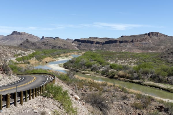 River Road FM 170 winding beside the Rio Grande in Big Bend Ranch State Park, with desert hills and mesas beyond.