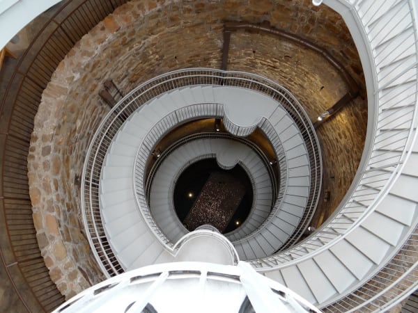 Looking down the stone-lined Big Well in Greensburg, a white spiral staircase winding to the bottom.