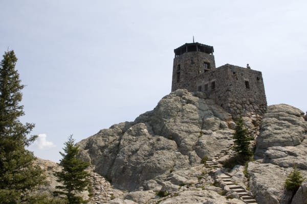 The stone fire lookout tower on the granite summit of Black Elk Peak, with stone steps leading up to it