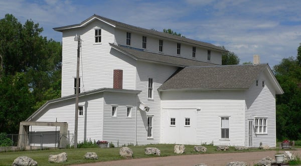 The white clapboard Champion Mill rises three stories above its lower wings in the village of Champion.