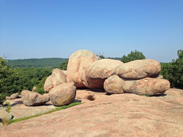 A line of huge rounded pink granite boulders on bare granite bedrock at Elephant Rocks State Park.