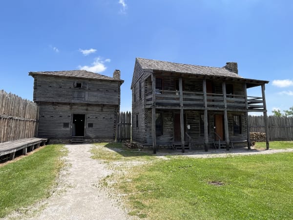 The reconstructed log blockhouse and two-story factory building inside the stockade at Fort Osage.
