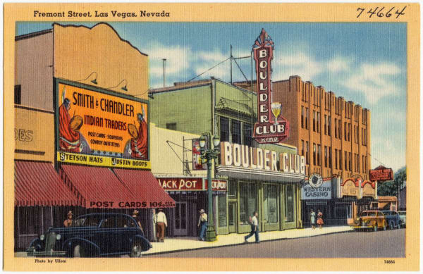 A linen postcard captioned "Fremont Street, Las Vegas, Nevada" — the Boulder Club's tall neon sign above its storefront, a painted Smith & Chandler Indian Traders billboard on the wall alongside, the Jack Pot and Western Casino further down the block, and period cars at the kerb.
