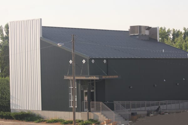 The Great Plains Dinosaur Museum in Malta, a dark metal-clad building with a pale tower at one corner