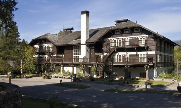 Lake McDonald Lodge, a Swiss chalet of dark timber and white walls with wooden balconies, among the trees