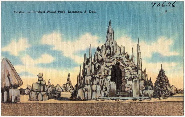 A mid-century postcard of the castle built of petrified wood in Lemmon's Petrified Wood Park, surrounded by spires and cones of the same stone