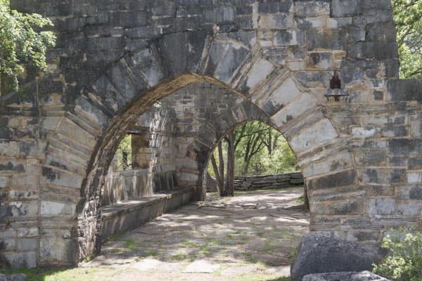 Arched stone walls and a stone walkway built by the Civilian Conservation Corps near the entrance to Longhorn Cavern.
