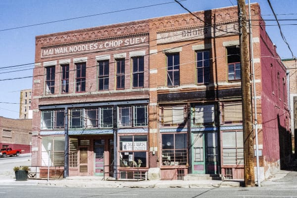 The Mai Wah building on Mercury Street in Butte, red brick with a painted sign for noodles and chop suey across its cornice