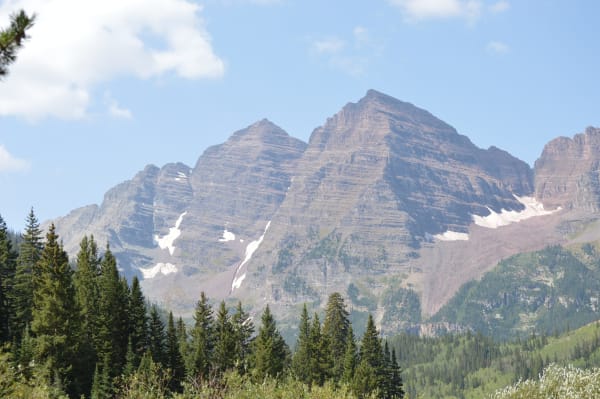 The banded red peaks of the Maroon Bells above spruce forest, seen from near Crater Lake