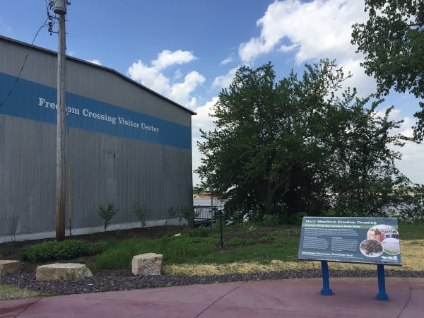 The Freedom Crossing visitor building and an interpretive sign beside the riverfront trail in north St. Louis.
