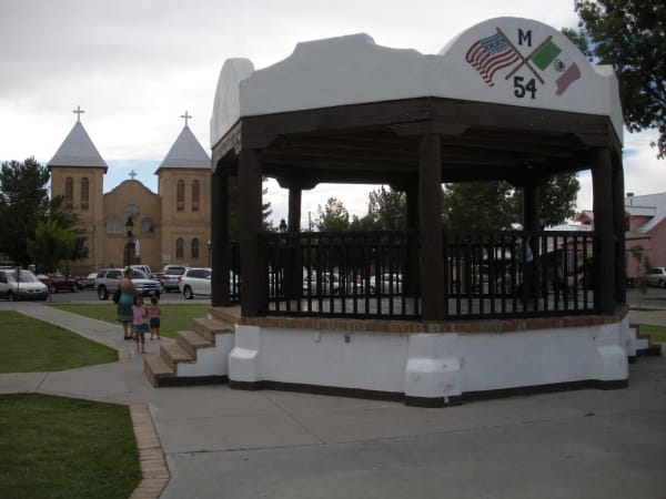 The white bandstand on Mesilla Plaza with the twin towers of the Basilica of San Albino behind it