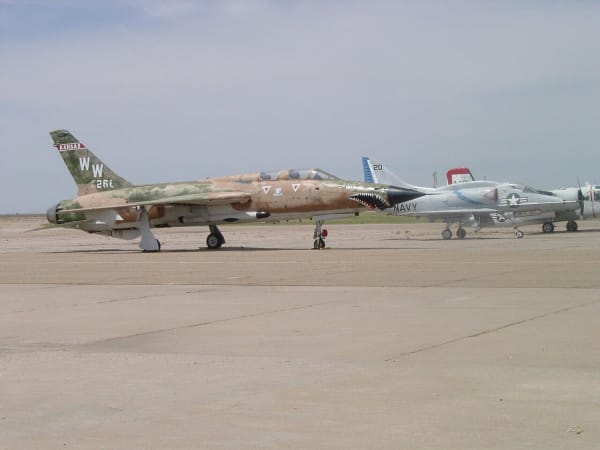 A camouflaged F-105 Thunderchief and other jets parked on the apron outside the Mid-America Air Museum.