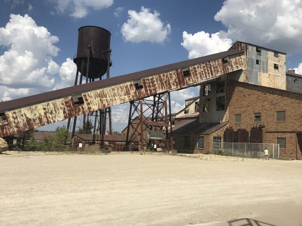 The rusted conveyor, water tower and brick mill buildings of the old Federal Mill at Missouri Mines State Historic Site.
