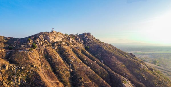 Mount Rubidoux from the air, its granite spine rising above Riverside with the valley hazy beyond.