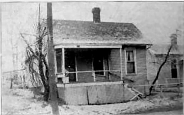 The first American School of Osteopathy building in Kirksville, a small frame house with a porch, in a photograph published in 1911.