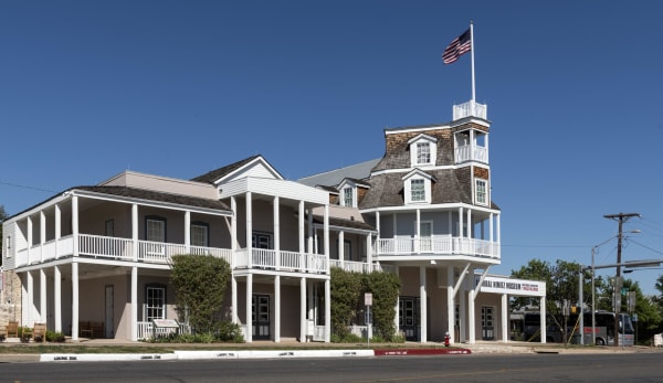 The white Nimitz Hotel on Main Street in Fredericksburg, with long porches and its tall steamboat-shaped front topped by a flag.
