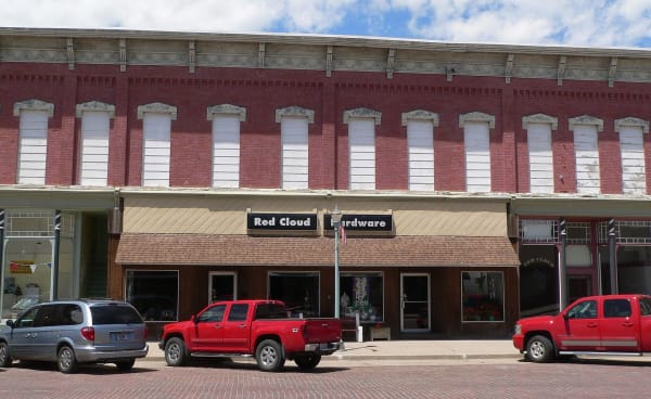 The two-story red-brick Moon Block, with arched upper windows and storefronts, lines Webster Street in Red Cloud.