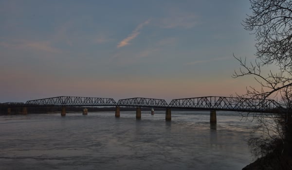 The steel truss spans of the Old Chain of Rocks Bridge crossing the Mississippi River at dusk.