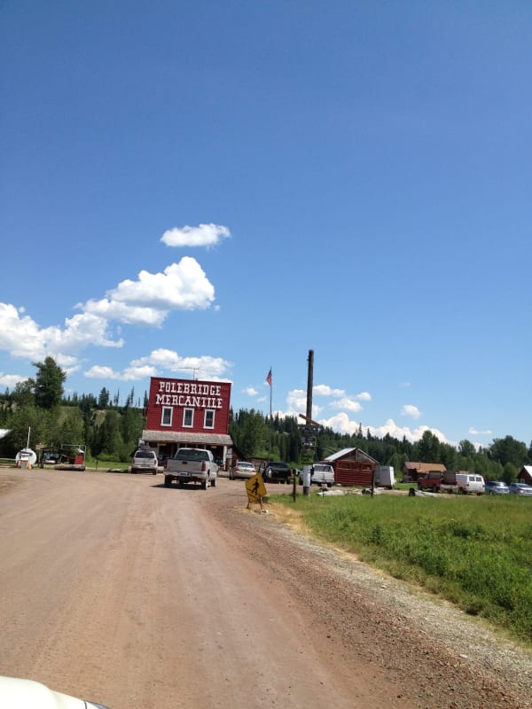 The red false-front Polebridge Mercantile at the end of a gravel road under a wide sky