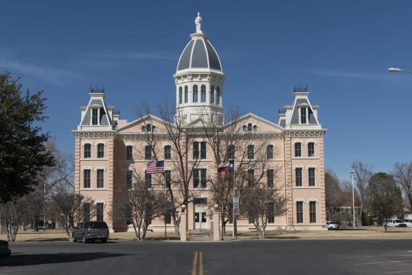 The domed Second Empire Presidio County Courthouse in Marfa, built of pink brick with a statue atop its cupola.