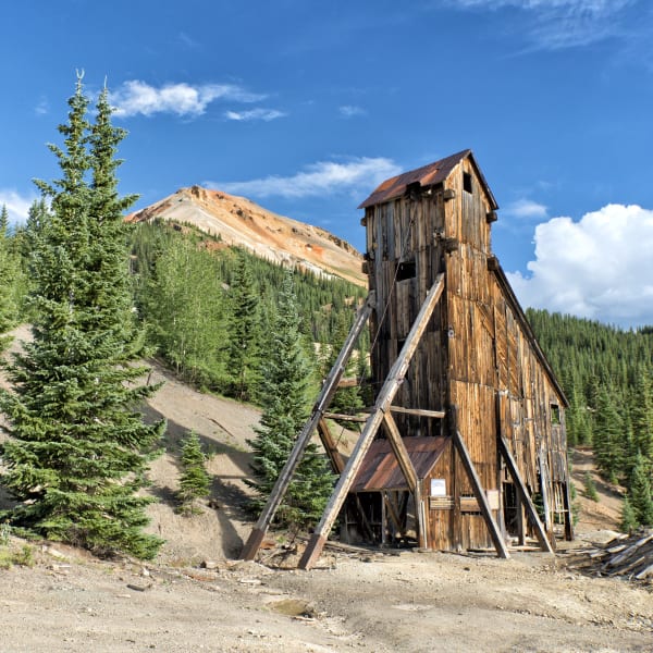 The wooden headframe of the Yankee Girl mine below a red-stained peak near Red Mountain Pass