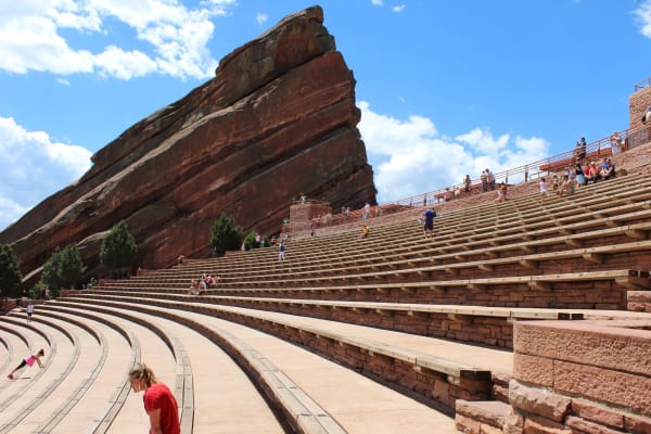 Stone seating at Red Rocks Amphitheatre rising beside one of its tilted red sandstone monoliths