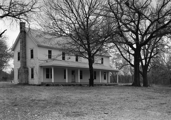The two-story frame Saline Courthouse and its long front porch among bare trees.