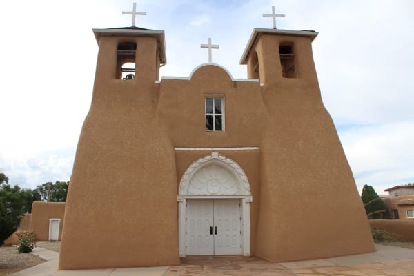 The adobe front of San Francisco de Asís at Ranchos de Taos, with twin bell towers and white wooden doors