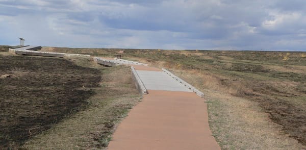 A concrete path and small bridges lead across the Santa Fe Trail ruts on the shortgrass west of Dodge City.