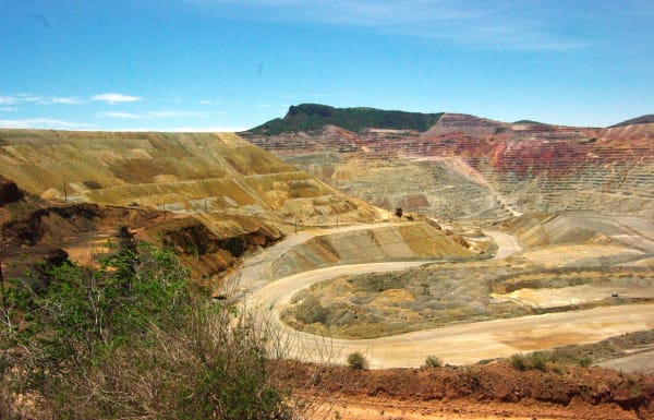 The terraced walls and haul roads of the open-pit copper mine at Santa Rita, banded in yellow and red